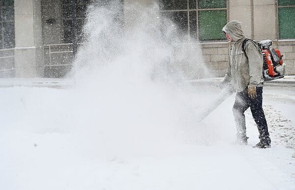 Public employees with the help of work release inmates clearing snow off the sidewalks on Neville Street in downtown Beckley, W.Va., Tuesday, Feb. 11, 2025. (Rick Barbero/The Register-Herald via AP)