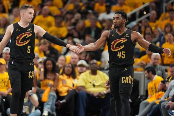 Cleveland Cavaliers guard Sam Merrill (5) and guard Donovan Mitchell (45) celebrate during the second half of Game 3 in the Eastern Conference semifinals of the NBA basketball playoffs against the Indiana Pacers in Indianapolis, Friday, May 9, 2025. (AP Photo/Michael Conroy)