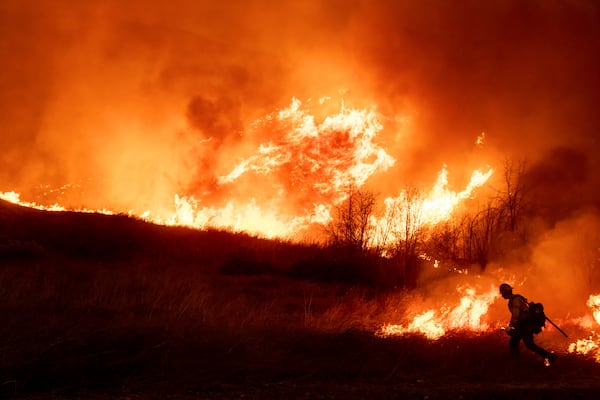 A firefighter sets a backburn in front of the advancing Kenneth Fire in the West Hills section of Los Angeles, Thursday, Jan. 9, 2025. (AP Photo/Ethan Swope)