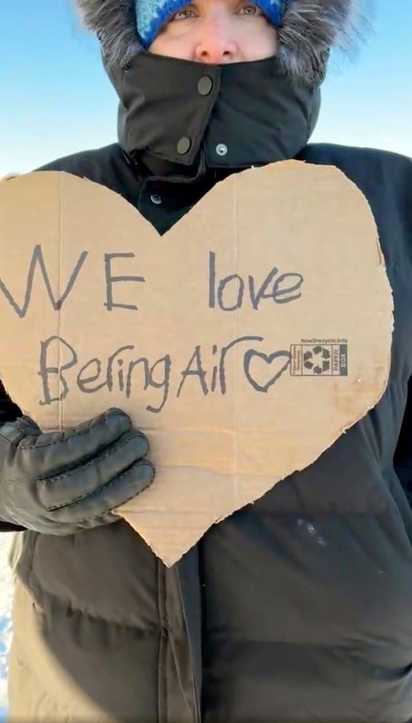 In this screen grab from a Facebook livestream, a resident of the Inupiat Eskimo village of Golovin in Alaska holds a sign that says ‘We Love Bering Air’ on Saturday, Feb. 8, 2025. (AP via Irene Navarro)