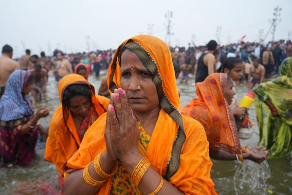 Hindu devotees pray after taking a holy dip in the Sangam, the confluence of the Ganges, the Yamuna and the mythical Saraswati rivers, on "Mauni Amavasya" or new moon day during the Maha Kumbh festival in Prayagraj, India, Wednesday, Jan. 29, 2025. (AP Photo/Deepak Sharma)