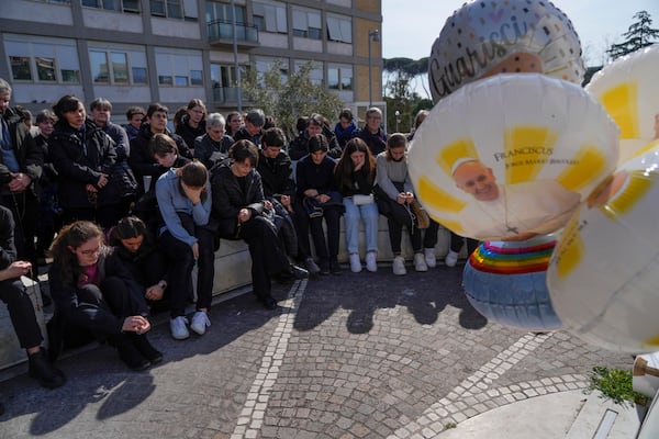 People pray outside the Agostino Gemelli Polyclinic in Rome, Sunday, Feb. 23, 2025, where Pope Francis is hospitalized since Feb. 14. (AP Photo/Gregorio Borgia)