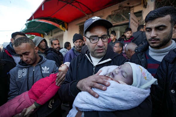 EDS NOTE: GRAPHIC CONTENT - Relatives react as they carry the bodies of children who were killed by an Israeli airstrike on the Gaza Strip at the Al-Aqsa Hospital in Deir al-Balah, Tuesday, Jan. 14, 2025. (AP Photo/Abdel Kareem Hana)