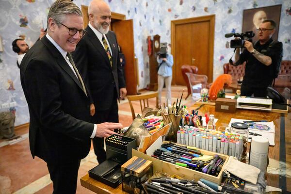 Britain's Prime Minister Keir Starmer, left, looks at the desk of Albania's Prime Minister Edi Rama, second left, at the Kryeministria in Tirana, Albania, Thursday May 15, 2025. (Leon Neal/Pool via AP)