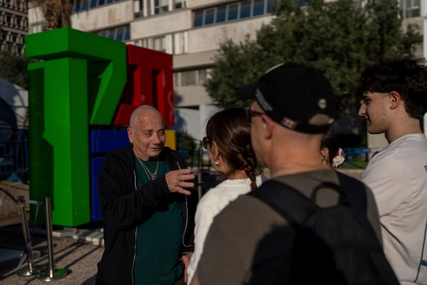 Luis Har, who was rescued from Hamas captivity in an Israeli raid last year, talks with visitors to the Hostages Square in Tel Aviv, Israel, Monday, Jan. 6, 2025. (AP Photo/Ohad Zwigenberg)