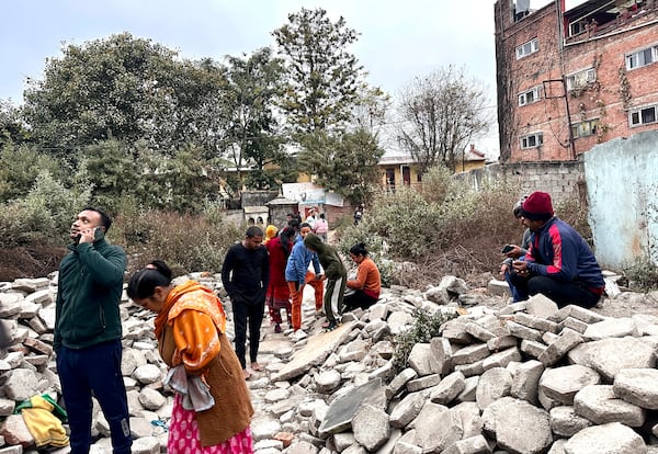 Nepalese people look on after rushing out of their homes after experiencing an earthquake in Kathmandu, Nepal, Tuesday, Jan.7, 2025. (AP Photo/Sunil Sharma)