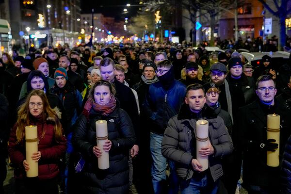 FILE - People carry candles attending an AfD election campaign in front of the cathedral in Magdeburg, Germany, on Dec. 23, 2024. (AP Photo/Ebrahim Noroozi, File)