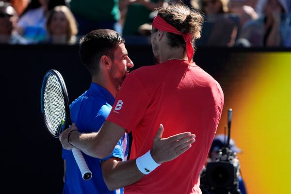 Alexander Zverev, right, of Germany is embraced by Novak Djokovic of Serbia after Djokovic retired in their semifinal match at the Australian Open tennis championship in Melbourne, Australia, Friday, Jan. 24, 2025. (AP Photo/Asanka Brendon Ratnayake)