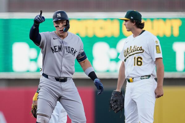 New York Yankees' Aaron Judge, left, reacts next to Athletics first baseman Nick Kurtz (16) after hitting a double during the first inning of a baseball game Friday, May 9, 2025, in West Sacramento, Calif. (AP Photo/Godofredo A. Vásquez)