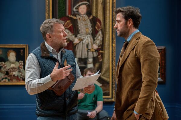 This image released by Apple TV+ shows Guy Ritchie, left, and John Krasinski on set of the film "Fountain of Youth." (Christopher Raphael/Apple TV+ via AP)