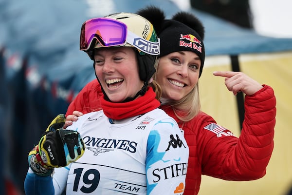 United States' A.J. Hurt and United States' Lindsey Vonn, right, smile at the finish area of a slalom run of a women's team combined event, at the Alpine Ski World Championships, in Saalbach-Hinterglemm, Austria, Tuesday, Feb. 11, 2025. (AP Photo/Marco Trovati)