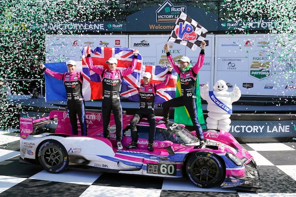 FILE - Winners of the Rolex 24 hour auto race, from left, Simon Pagenaud, of France, Oliver Jarvis, of Great Britain, Tom Blomqvist, of Monaco and Helio Castroneves, of Brazil celebrate in Victory Lane at Daytona International Speedway, Jan. 30, 2022, in Daytona Beach, Fla. (AP Photo/John Raoux, File)