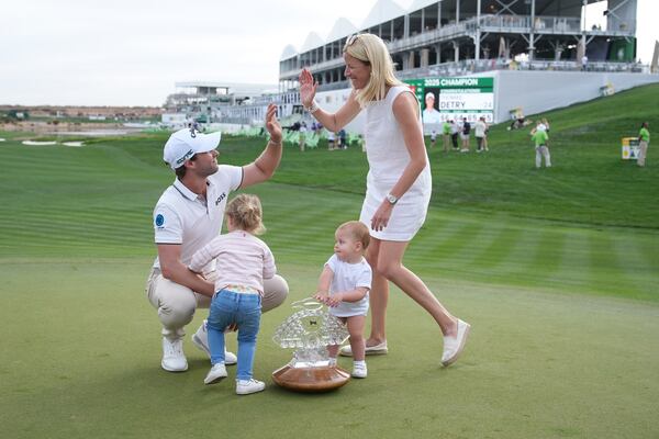 Thomas Detry, left, of Belgium, celebrates after his win at the Phoenix Open golf tournament at TPC Scottsdale with wife Sarah, right, and daughters Sophia, second from left, and Alba, second from right, Sunday, Feb. 9, 2025, in Scottsdale, Ariz. (AP Photo/Ross D. Franklin)