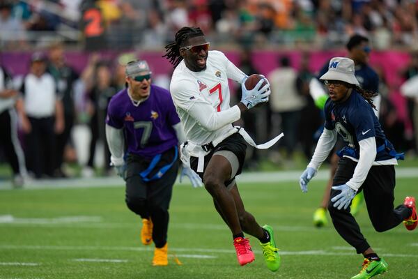 AFC wide receiver Brian Thomas Jr. (7), of the Jacksonville Jaguars, runs away from NFC return specialist KaVontae Turpin, of the Dallas Cowboys, right, during the flag football event at the NFL Pro Bowl, Sunday, Feb. 2, 2025, in Orlando. (AP Photo/Chris O'Meara)