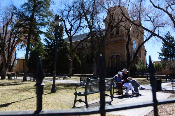 People walk around the Santa Fe Plaza in Santa Fe, New Mexico, Friday, Feb. 28, 2025. (AP Photo/Ty O'Neil)