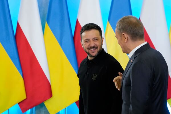 Polish Prime Minister Donald Tusk, right, welcomes Ukrainian President Volodymyr Zelenskyy after the two countries reached an agreement on a longstanding source of tensions between them: the exhumation of Polish victims of World War II-era massacres by Ukrainian nationalists, in Warsaw, Poland, on Wednesday, Jan. 15, 2025. (AP Photo/Czarek Sokolowski)