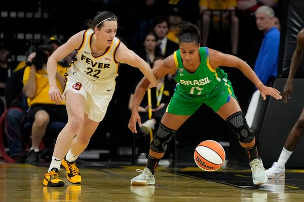 Indiana Fever guard Caitlin Clark (22) fights for the ball with Brazil guard Carina Martins (17) during the first half of an exhibition women's basketball game, Sunday, May 4, 2025, in Iowa City, Iowa. (AP Photo/Charlie Neibergall)