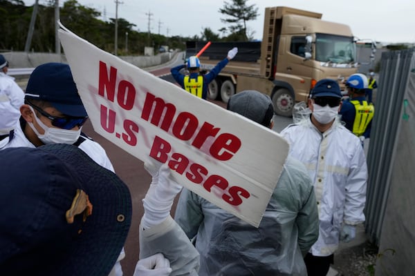 People chant slogans against construction along Camp Schwab, a U.S. Marine Corps base, as they protest in Nago, on the main island of the Okinawa archipelago, southern Japan, Tuesday, Feb. 18, 2025. (AP Photo/Hiro Komae)