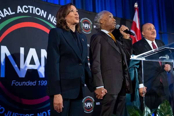 FILE - Vice President Kamala Harris, left, holds hands and sings "We Shall Overcome" with Rev. Al Sharpton and Martin Luther King III, at a National Action Network event in Washington, Jan. 15, 2025. (AP Photo/Jacquelyn Martin, File)