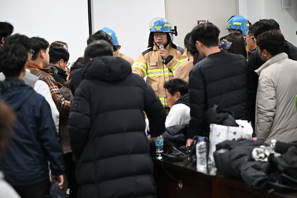 An official from fire station briefs to the family members of the passengers on a plane which burst into flames, at the Muan International Airport in Muan, South Korea, Sunday, Dec. 29, 2024. (Park Ki-woong/Newsis via AP)