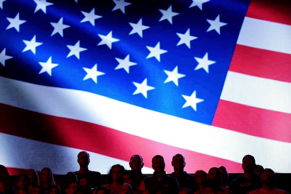 People stand for the national anthem before an NCAA college basketball game between Kansas and Iowa State, Monday, Feb. 3, 2025, in Lawrence, Kan. (AP Photo/Charlie Riedel)