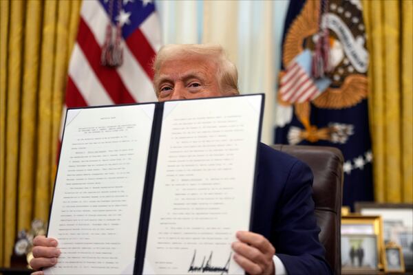 President Donald Trump signs an executive order in the Oval Office of the White House, Thursday, Jan. 23, 2025, in Washington. (AP Photo/Ben Curtis)