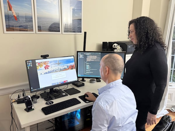 Michal Harel and her husband Avital Epstein show the website they set up to help Israelis navigate a move to Canada in Oakville, Ontario, Canada, Wednesday, Dec. 4, 2024. (AP Photo/Rob Gillies)