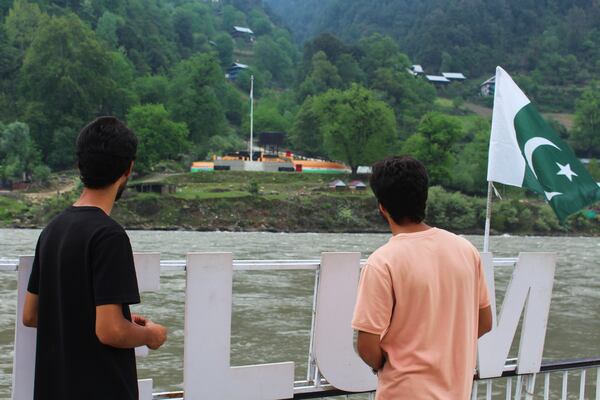 Local residents look at the Indian side of Kashmir from a tourists point in Karen, in the Neelum Valley near on the Line of Control, the de facto border that divides the disputed region of Kashmir, some 93 kilometres (58 miles) from Muzaffarabad, the capital of Pakistan controlled Kashmir, Thursday, May 1, 2025. (AP Photo/Ishfaq Hussain)
