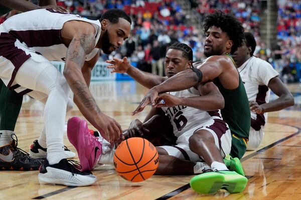 Mississippi State guard Dellquan Warren and guard Claudell Harris Jr., left, vie for a loose ball with Baylor forward Norchad Omier during the first half in the first round of the NCAA college basketball tournament, Friday, March 21, 2025, in Raleigh, N.C. (AP Photo/Chris Carlson)