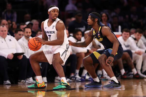 Xavier guard Ryan Conwell (7) looks to pass the ball past Marquette guard Chase Ross, right, during the second half of an NCAA college basketball game in the quarterfinals of the Big East Conference tournament, Thursday, March 13, 2025, in New York. (AP Photo/Pamela Smith)