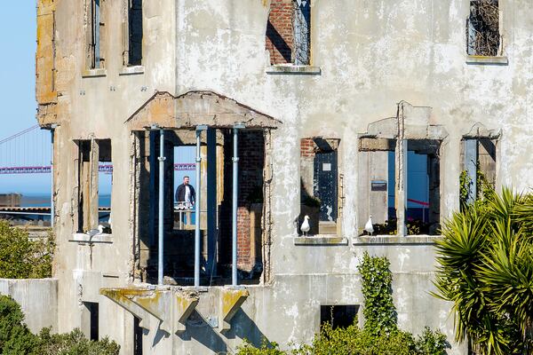 A visitor looks at the warden's house at Alcatraz Island on Monday, May 5, 2025, in San Francisco. (AP Photo/Noah Berger)