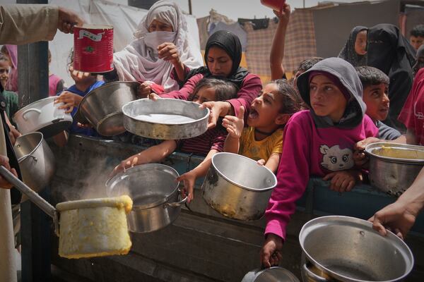 Palestinian children and women struggle to get donated food at a community kitchen in Khan Younis, southern Gaza Strip, Thursday April 24, 2025.(AP Photo/Abdel Kareem Hana)