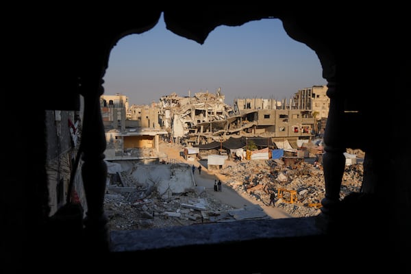 FILE - Palestinians walk through the destruction in the wake of an Israeli air and ground offensive in Khan Younis, southern Gaza Strip, on Jan. 7, 2025. (AP Photo/Abdel Kareem Hana, File)