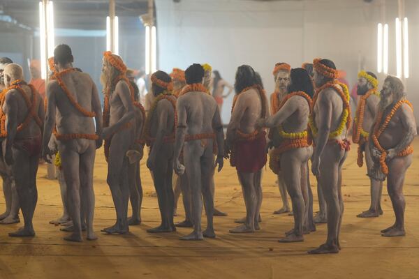 Naked Hindu holy men or a Naga Sadhus of Maharirwani Akhara gets ready at their camp for a dip at Sangam, the confluence of the Rivers Ganges, Yamuna and mythical Saraswati on one of the most auspicious day Makar Sankranti, for the Maha Kumbh festival, which is one of the world's largest religious gatherings, celebrated every 12 years in Prayagraj, in the northern Indian state of Uttar Pradesh, India, Tuesday, Jan. 14, 2025. (AP Photo/Rajesh Kumar Singh)