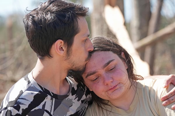 Steve Romero, comforts his fiancee, Hailey Hart, right, Sunday, March 16, 2024, after recalling how the couple and their three dogs rode out an apparent tornado in their small automobile, Saturday afternoon, in Tylertown, Miss. (AP Photo/Rogelio V. Solis)