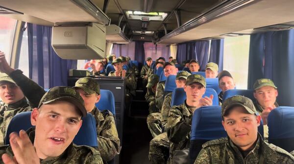 In this photo taken from video distributed by Russian Defense Ministry Press Service on Tuesday, May 6, 2025, a group of Russian soldiers applaud as they sit in a bus after being released in a prisoners swap between Russia and Ukraine, at the Ukraine-Belarusian boarder. (Russian Defense Ministry Press Service via AP)