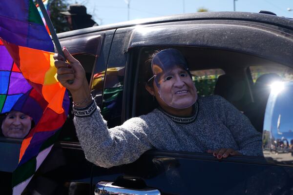 A man wearing a mask depicting former President Evo Morales tales part in a caravan to the Electoral Tribunal offices in El Alto, Bolivia, Friday, May 16, 2025. (AP Photo/Juan Karita)