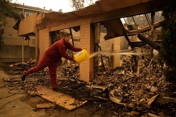 Shane Torre douses hot spots of what remains of his home in Altadena, Calif., Thursday, Jan. 9, 2025. (AP Photo/John Locher)