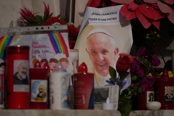 An image of Pope Francis is seen among candles in front of the Agostino Gemelli Polyclinic, in Rome, Sunday, Feb. 23, 2025, where the Pontiff is hospitalized since Friday, Feb. 14. (AP Photo/Andrew Medichini)