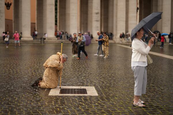 A faithful prays in St. Peter's Square during a final Mass by cardinals ahead of the conclave, at the Vatican, Wednesday, May 7, 2025. (AP Photo/Francisco Seco)