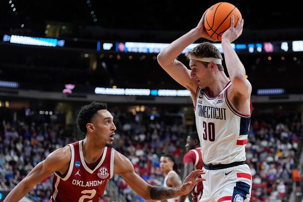 UConn forward Liam McNeeley (30) looks to drive past Oklahoma guard Brycen Goodine (2) during the first half in the first round of the NCAA college basketball tournament, Friday, March 21, 2025, in Raleigh, N.C. (AP Photo/Stephanie Scarbrough)