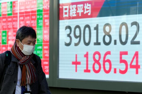 A person walks in front of an electronic stock board showing Japan's Nikkei index at a securities firm Thursday, Feb. 6, 2025, in Tokyo. (AP Photo/Eugene Hoshiko)