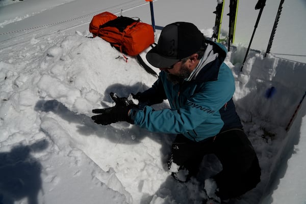 Ethan Greene, director of the Colorado Avalanche Information Center, tosses snow from a demonstration snow pit Wednesday, March 5, 2025, in Leadville, Colo. (AP Photo/Brittany Peterson)