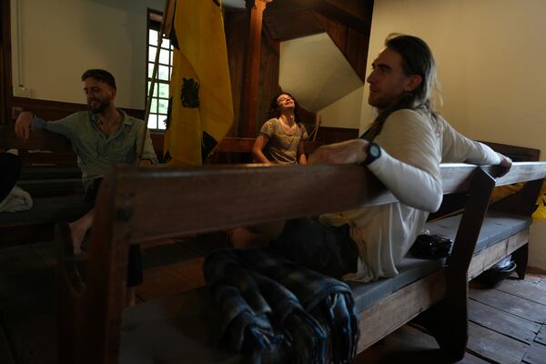 Max Goodman, left, Jules Wing Vasquez, center, and Ross Brubeck rest in the Quaker Meeting House in Princeton, N.J., after completing a portion of a Quaker march from New York City to Washington D.C., to protest President Donald Trump's crackdown on immigrants on Wednesday May 7, 2025. (AP Photo/Luis Andres Henao)
