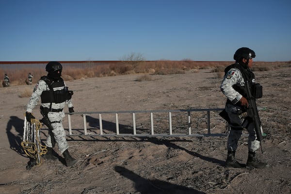 Mexican National Guard members carry a ladder they found while on patrol patrol along the Mexico-US border in Ciudad Juarez, Wednesday, Feb. 5, 2025. (AP Photo/Christian Chavez)