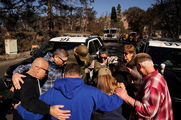 Members of Calvary Disaster Relief pray with some Los Angeles County sheriff's deputies, Wednesday, Jan. 15, 2025, in Altadena, Calif. (AP Photo/John Locher)