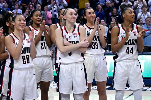 UConn's Paige Bueckers, center, reacts as her number is revealed on the Huskies of Honor Wall during senior day ceremonies after an NCAA college basketball game against Marquette, Sunday, March 2, 2025, in Storrs, Conn. (AP Photo/Jessica Hill)