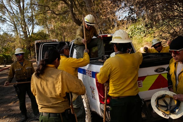 Firefighters from the Navajo Scouts firefighter crew unload hand tools from a truck at the Eaton Fire, Friday, Jan. 17, 2025, in Altadena, Calif. (AP Photo/John Locher)