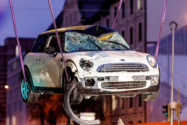 A car is lifted onto a tow truck at the scene where a driver drove a car into a labor union demonstration in Munich, Germany, Thursday Feb. 13, 2025. (Matthias Balk/dpa via AP)