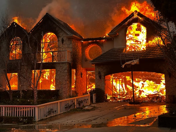 The Palisades Fire burns a structure in the Pacific Palisades neighborhood of Los Angeles, Wednesday, Jan. 8, 2025. (AP Photo/Eugene Garcia)